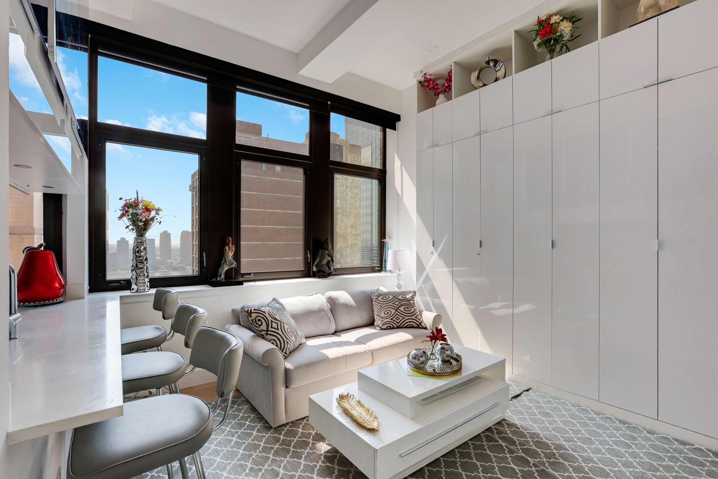 310 East 46th Street, Unit 20H Manhattan, NY 10017 - Photo 4 of 9 a living room with furniture and a window