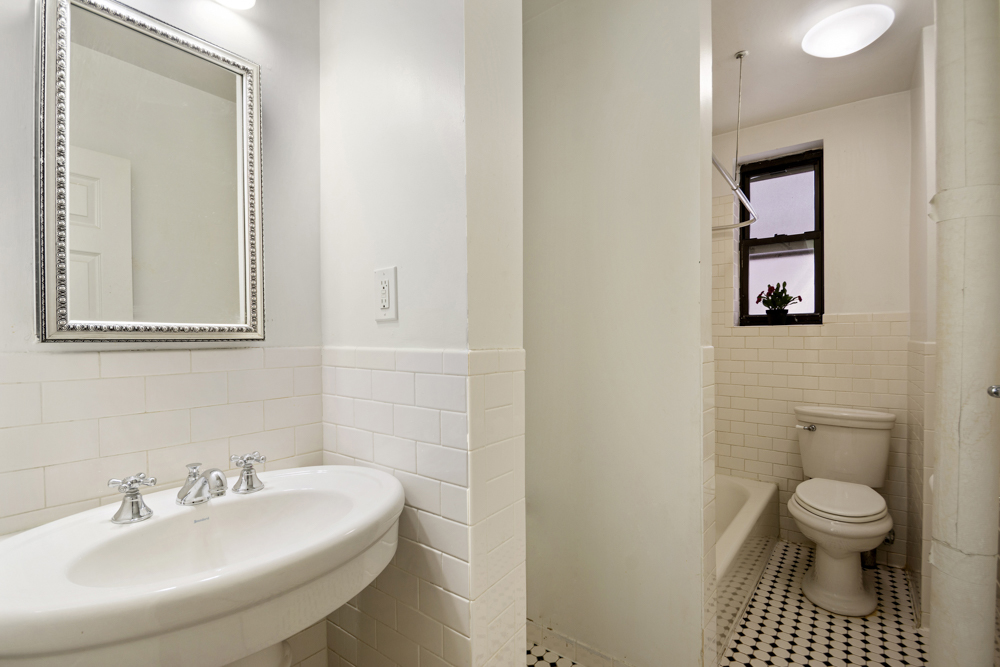 779 Riverside Drive, Unit A50 Manhattan, NY 10032 - Photo 8 of 14 a bathroom with a toilet a sink and mirror