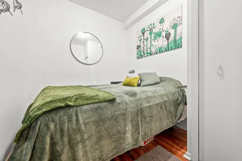 a bedroom with a bed and a painting on the wall