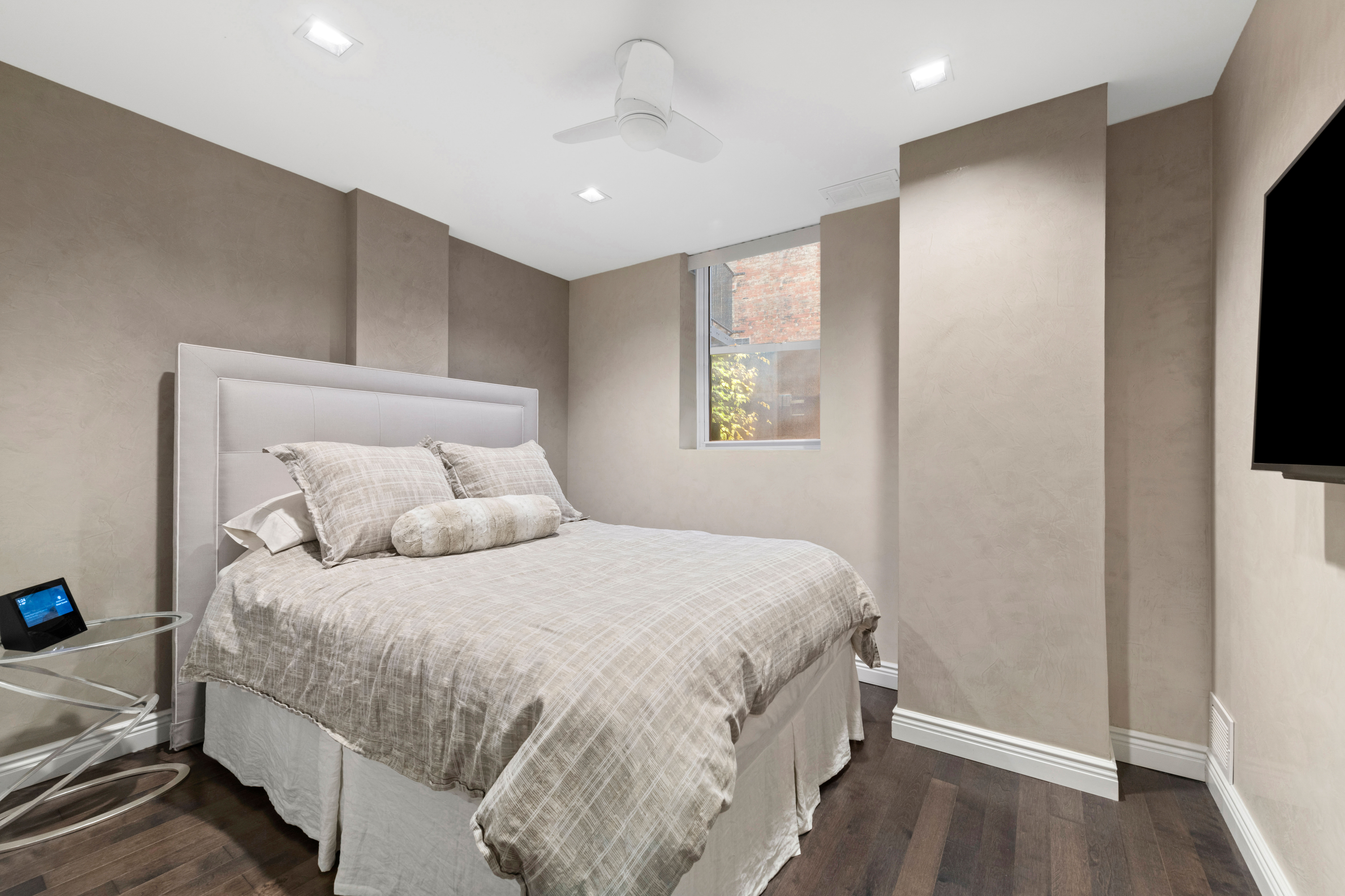 1 West 67th Street, Unit 206 Manhattan, NY 10023 - Photo 5 of 13 a bedroom with a bed and a flat tv screen on dresser