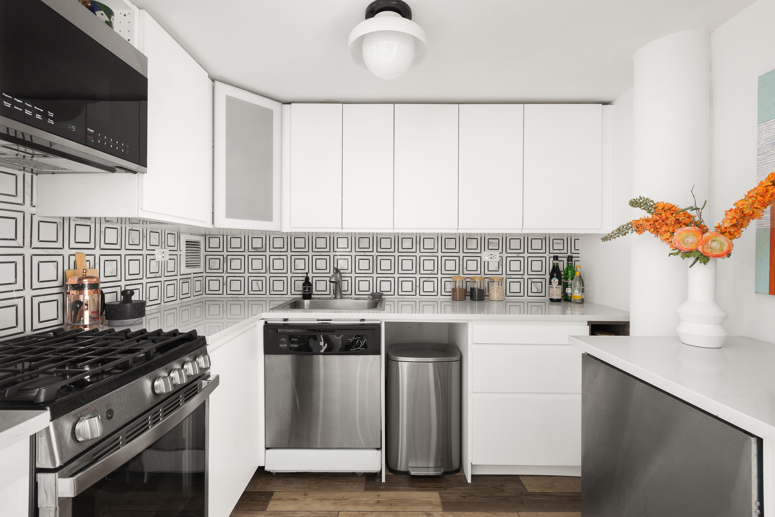 250 Mercer Street, Unit C415 Manhattan, NY 10012 - Photo 5 of 11 a kitchen with a stove a sink and a microwave