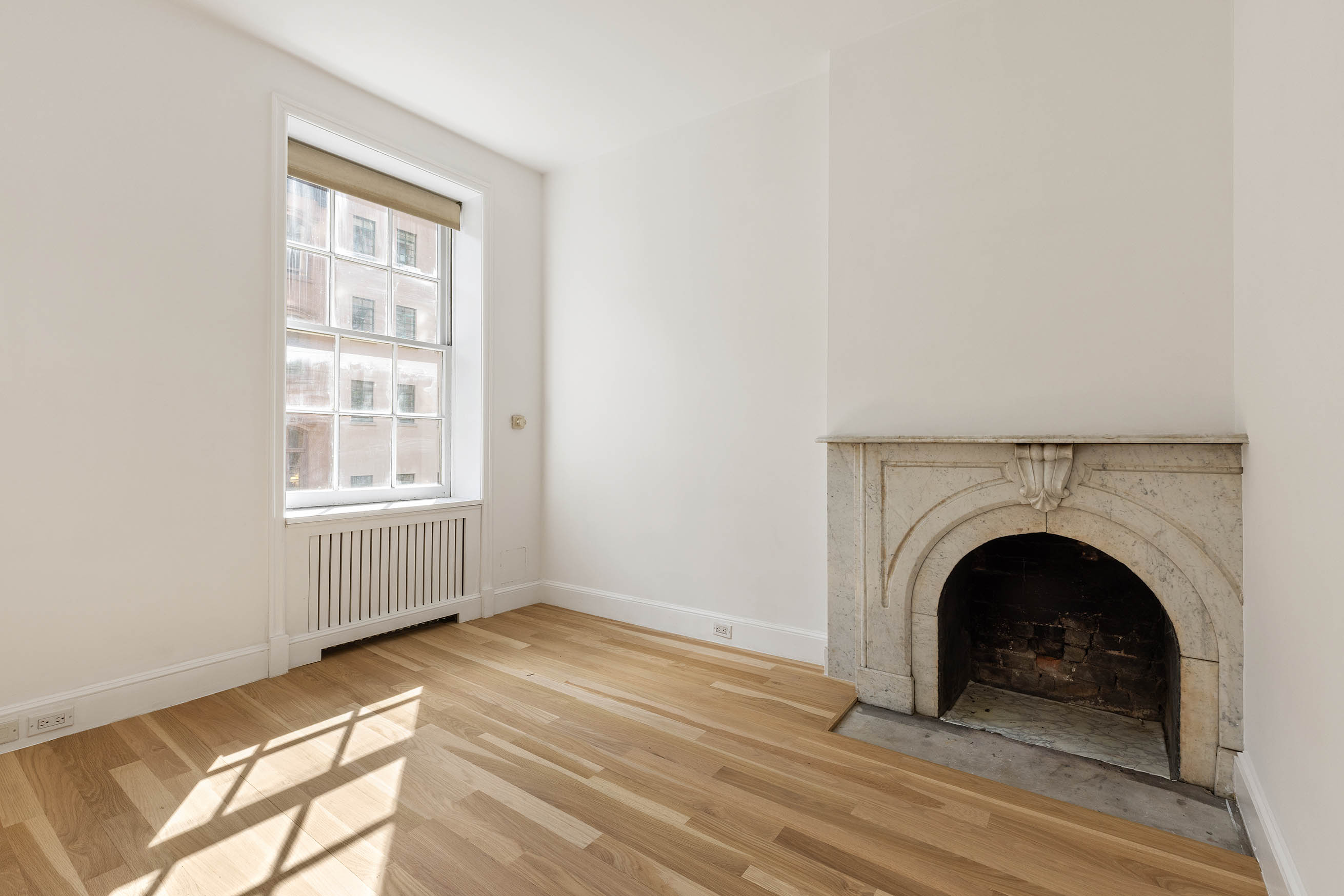23 West 12th Street, Unit 1 Manhattan, NY 10011 - Photo 10 of 13 a view of livingroom with wooden floor and a fireplace