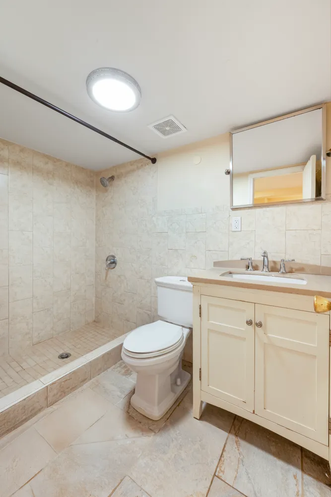 a bathroom with a granite countertop sink a toilet and shower