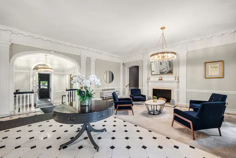 a living room with furniture a chandelier and a fireplace