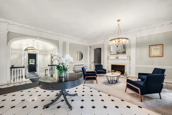 a living room with furniture a chandelier and a fireplace