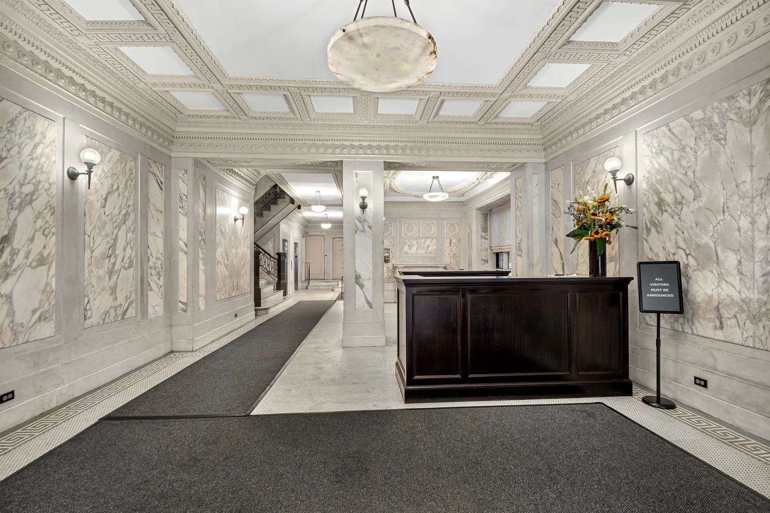 a view of a hallway with a fireplace and a chandelier