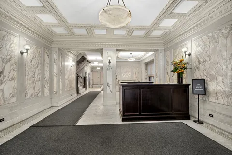 a view of a hallway with a fireplace and a chandelier