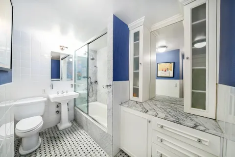 a bathroom with a sink a toilet and shower