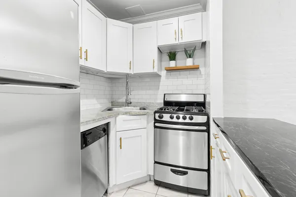 a kitchen with white cabinets and appliances