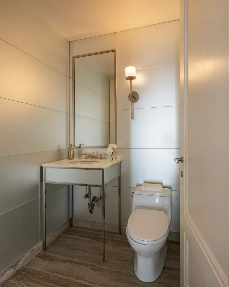 a bathroom with a toilet a sink and mirror