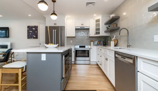a kitchen with stainless steel appliances granite countertop a sink a stove and a refrigerator