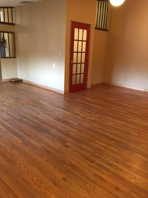 an empty room with wooden floor and shelves