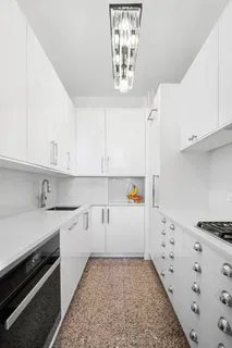a kitchen with granite countertop white cabinets and white appliances