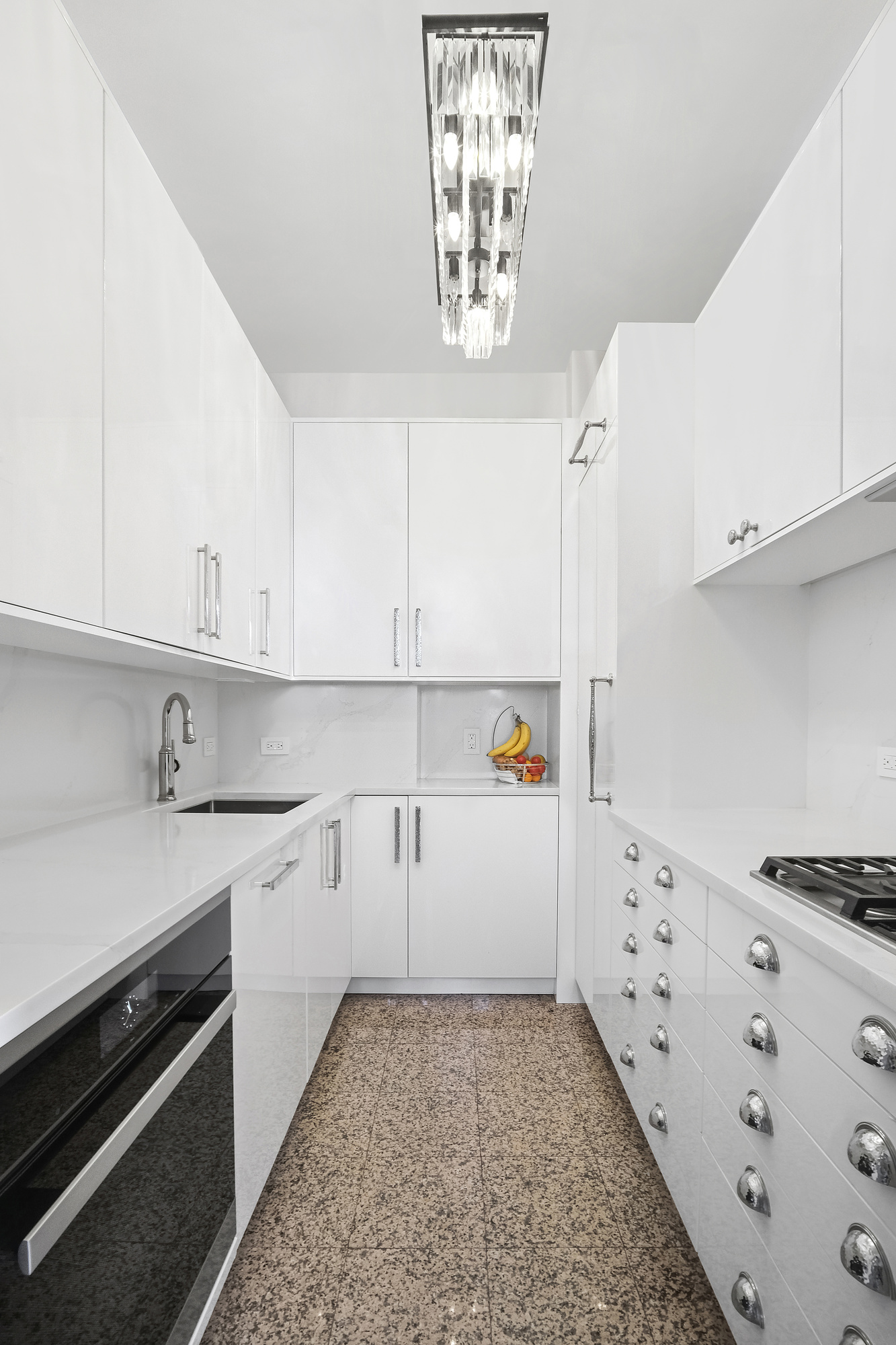 167 East 61st Street, Unit 23D Manhattan, NY 10065 - Photo 2 of 13 a kitchen with granite countertop white cabinets and white appliances