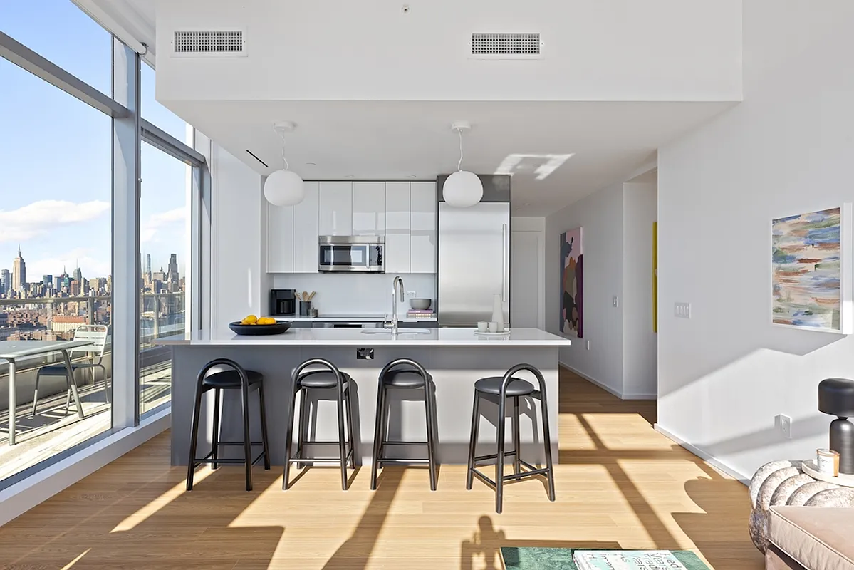 5 South 5th Street, Unit PH2B Brooklyn, NY 11249 - Photo 4 of 27 a view of a kitchen with stainless steel appliances granite countertop a stove a sink dishwasher and white cabinets with wooden floor