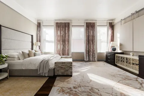 a spacious bedroom with a bed a couch and a window