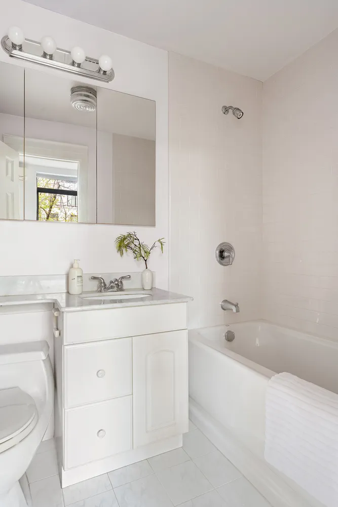 a bathroom with a granite countertop sink a toilet and bathtub