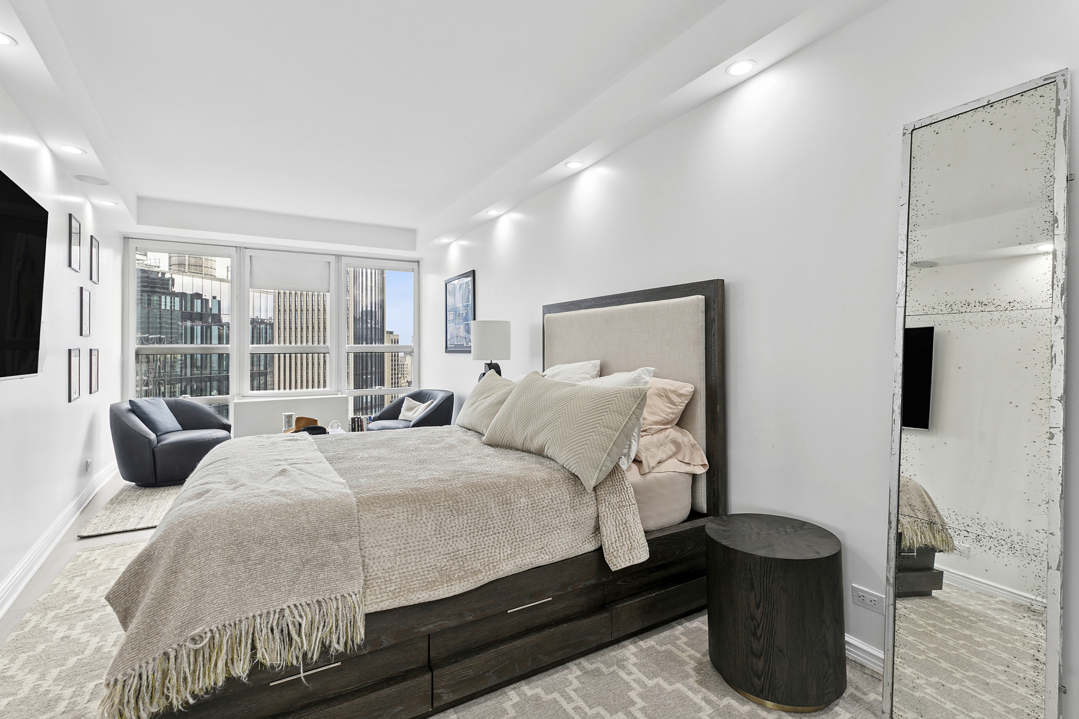 146 West 57th Street, Unit 47B Manhattan, NY 10019 - Photo 6 of 15 a bedroom with a bed and a large window