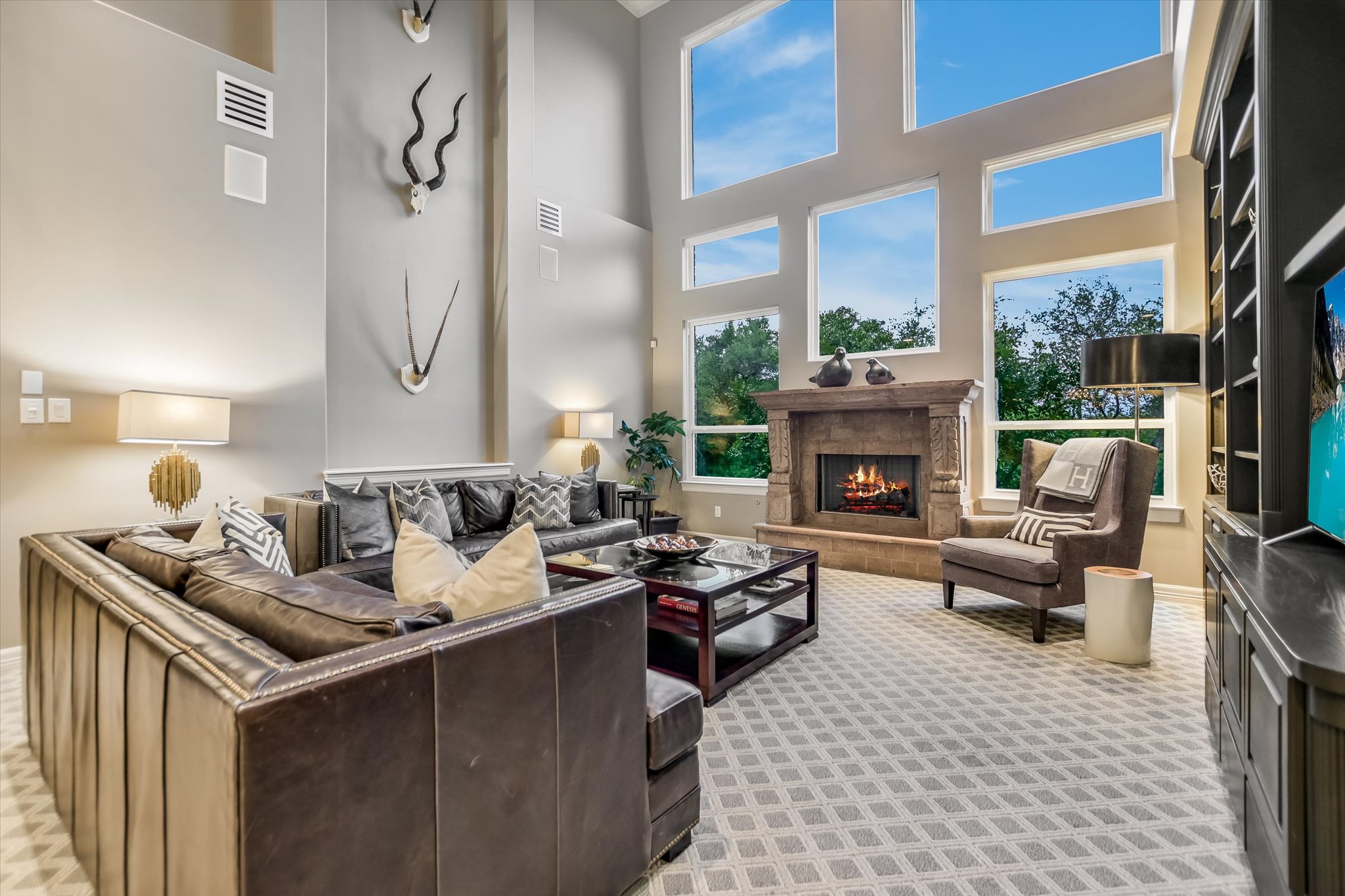 1422 Palomino Ridge Drive Austin, TX 78733 - Photo 17 of 60 a living room with furniture a fireplace and a floor to ceiling window