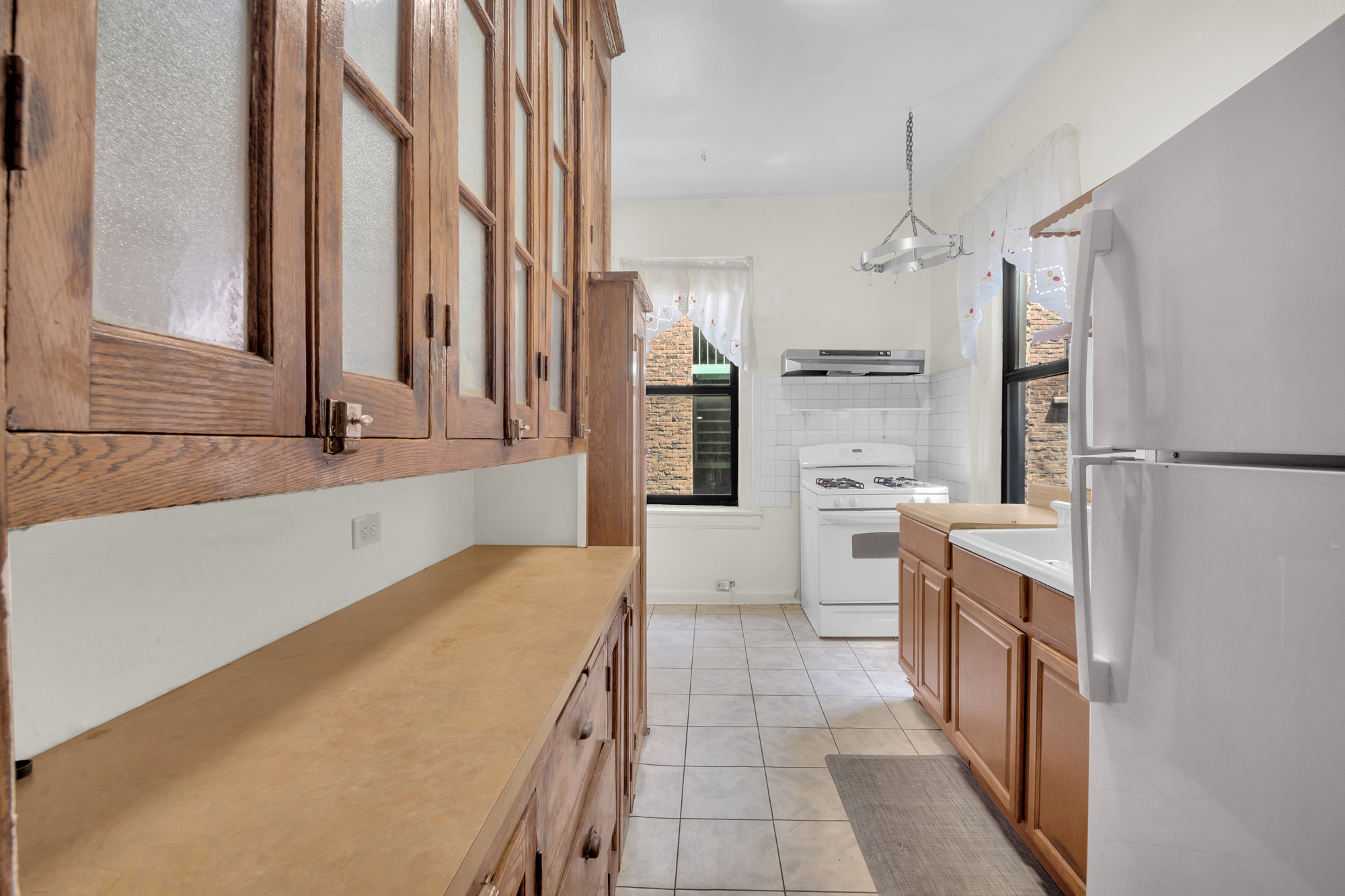 302 Convent Avenue, Unit 43 Manhattan, NY 10031 - Photo 3 of 5 a kitchen with white cabinets and white appliances