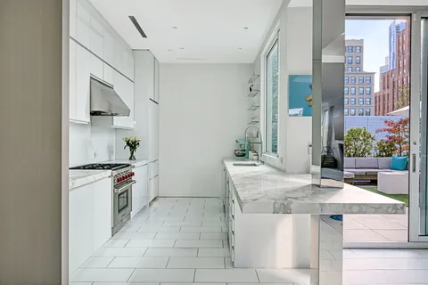 a kitchen with stainless steel appliances granite countertop a stove a sink and a refrigerator