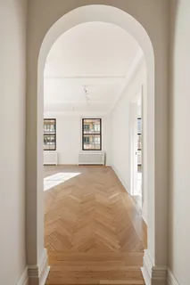 an empty room with windows and cabinet
