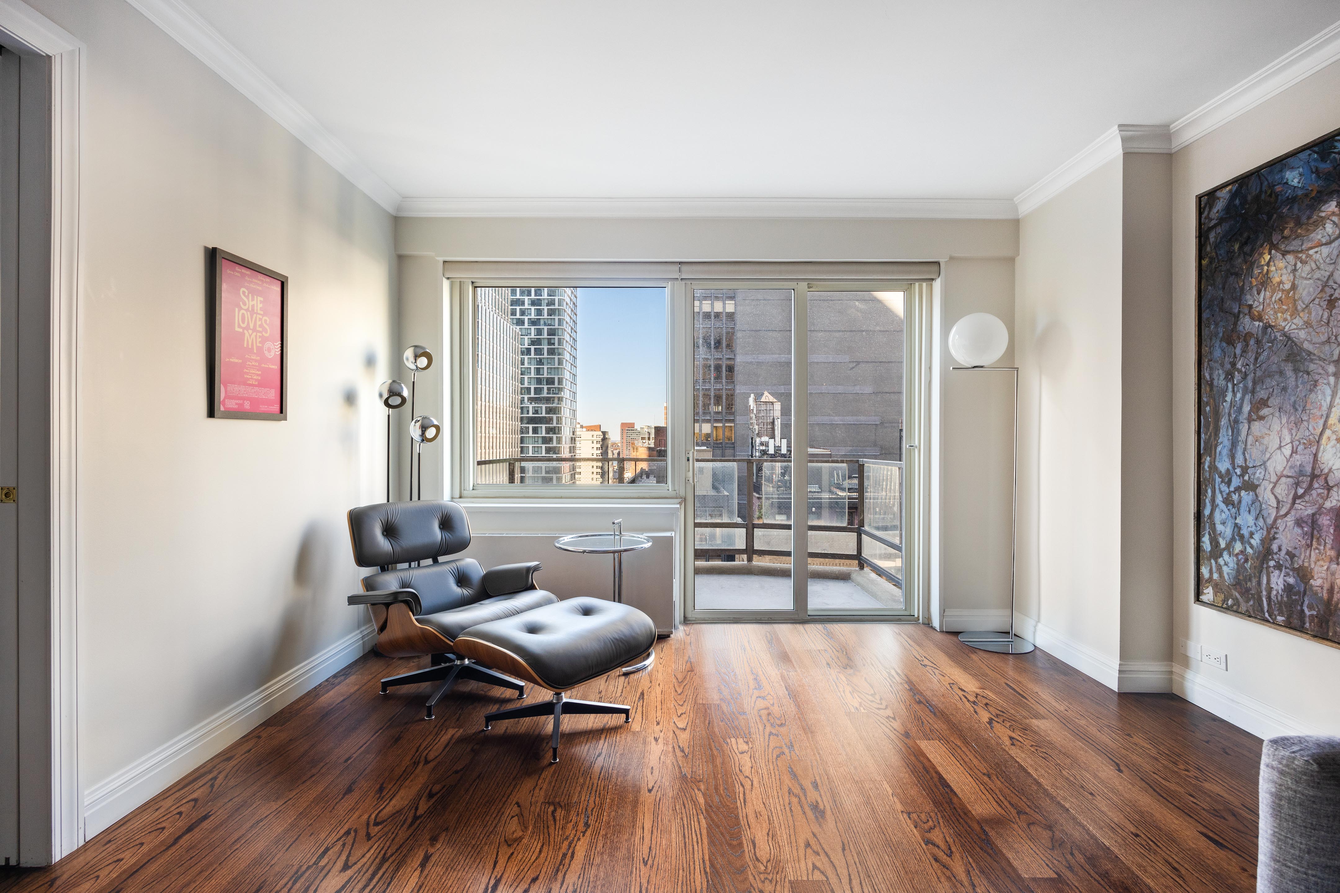 159 West 53rd Street, Unit 16E Manhattan, NY 10019 - Photo 2 of 10 a living room with furniture and a wooden floor