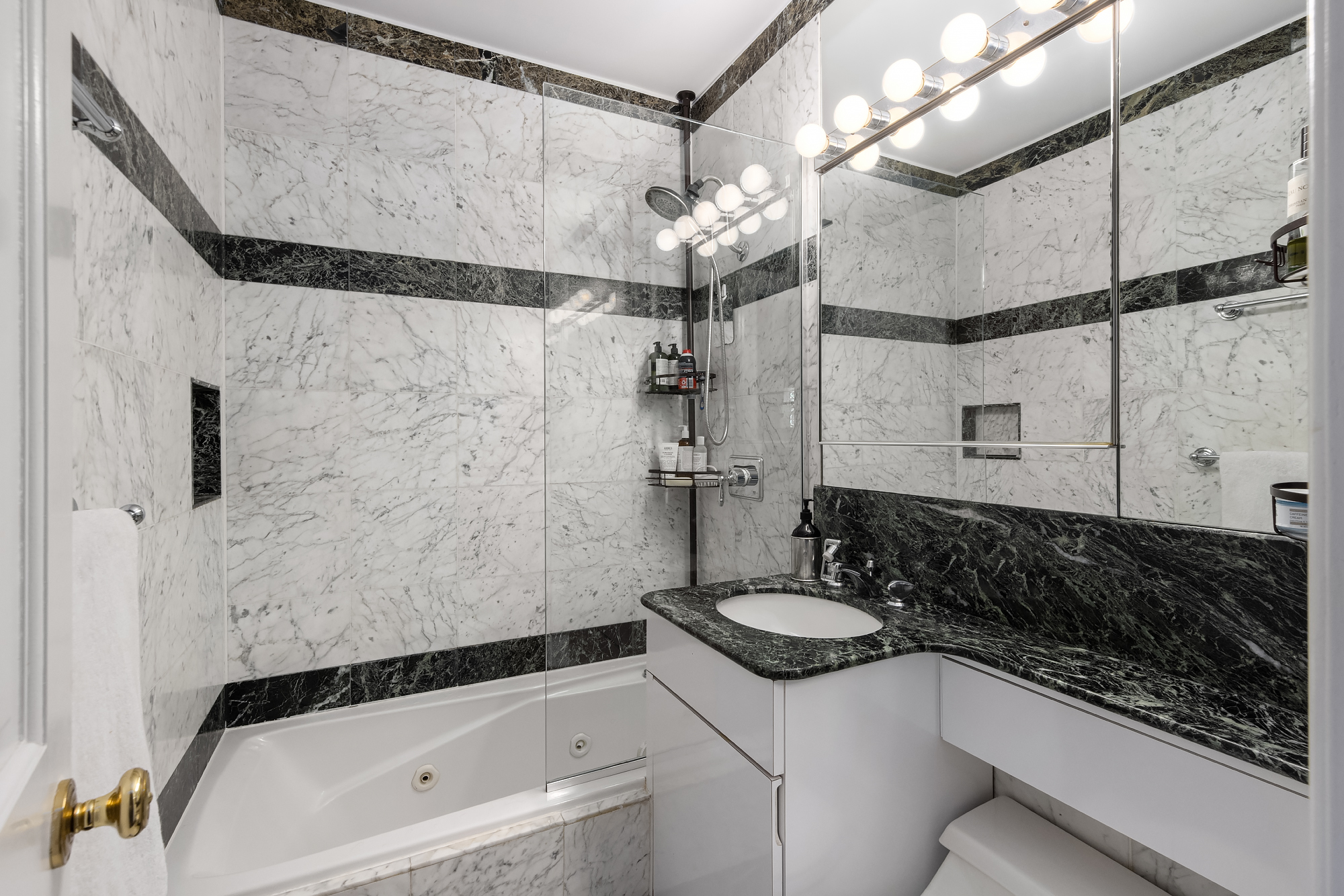 159 West 13th Street Manhattan, NY 10011 - Photo 28 of 36 a bathroom with a sink a mirror and a bathtub