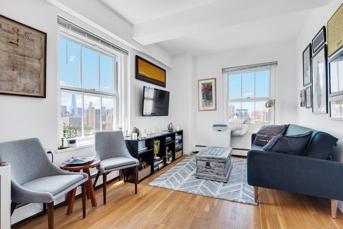 143 Avenue B, Unit 12E Manhattan, NY 10009 - Photo 3 of 8 a living room with furniture fireplace and a flat screen tv