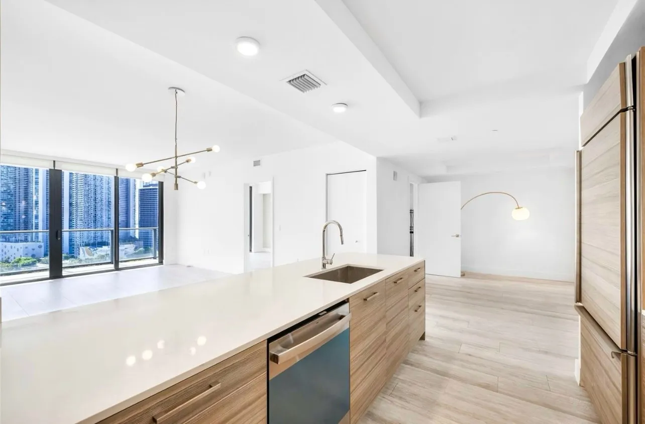 a kitchen with stainless steel appliances granite countertop a sink a counter space and a window