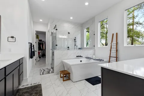 a bathroom with a tub sink and mirror