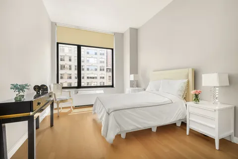 a bedroom with a bed and a large window