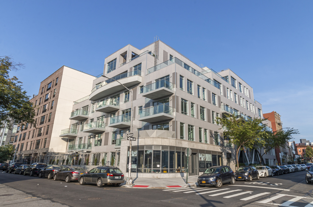 147 Hope Street, Unit 4A Brooklyn, NY 11211 - Photo 9 of 12 a front view of a building with lot of cars and trees