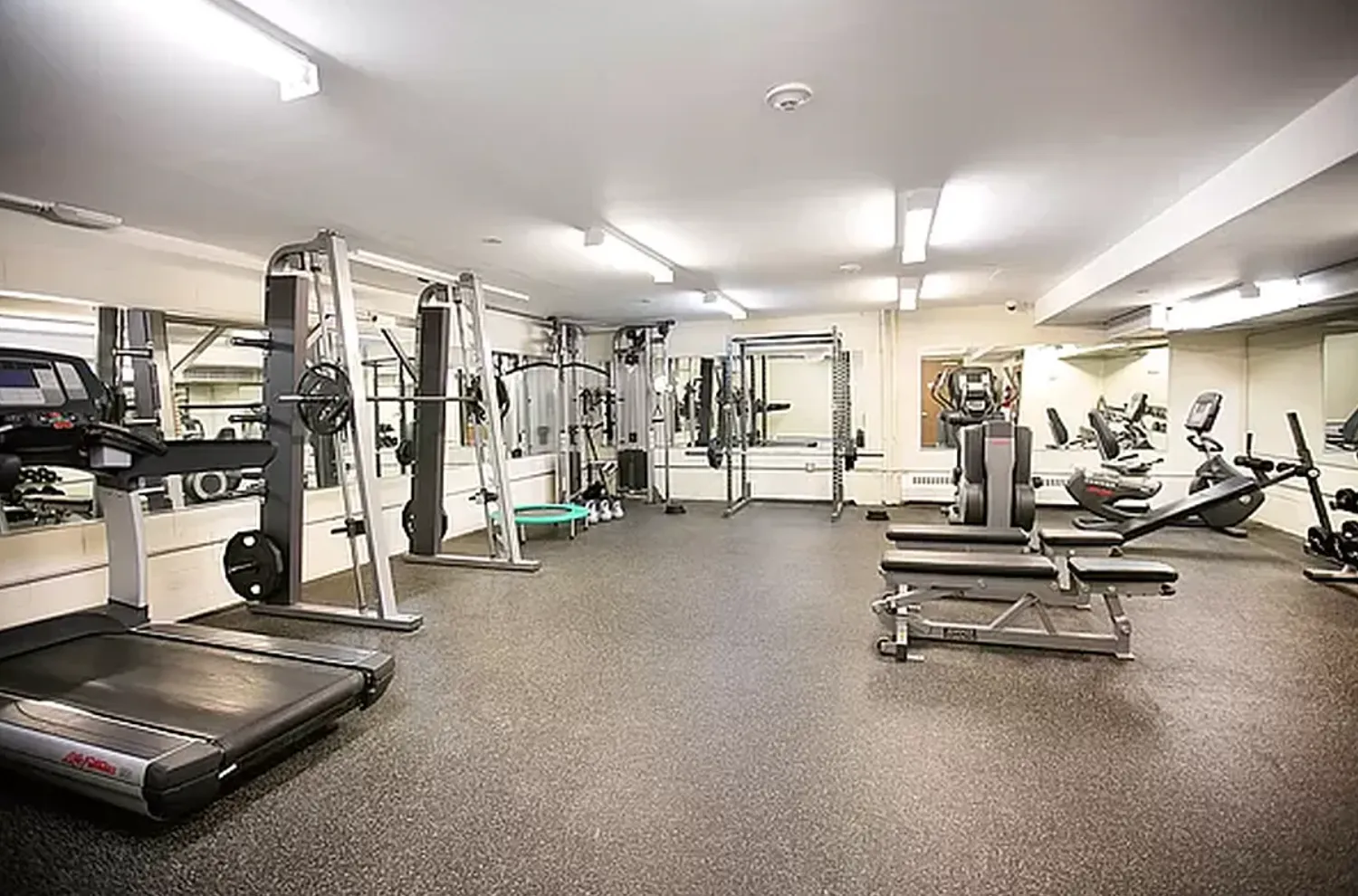a room with gym equipment and mirrors