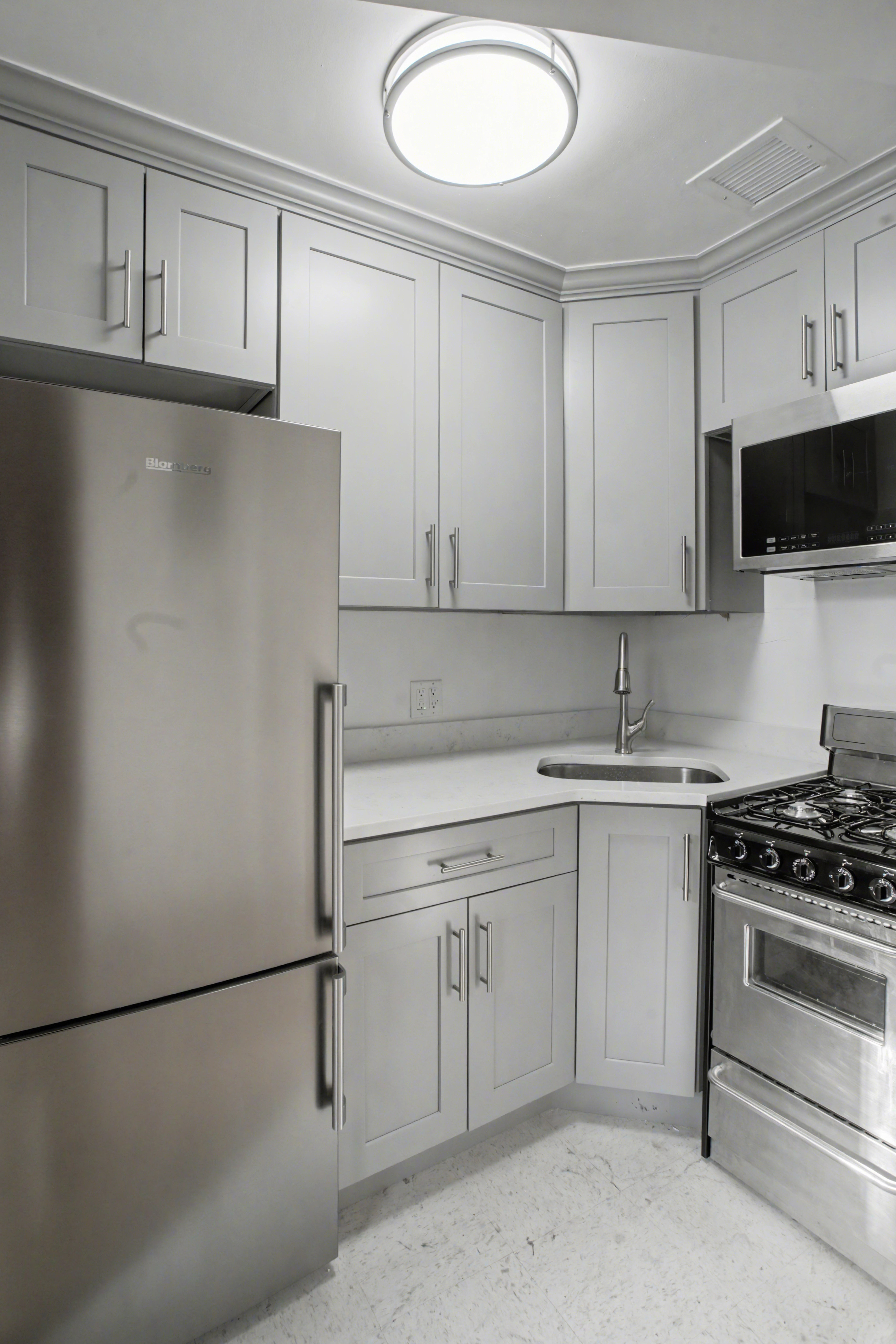 247 West 123rd Street, Unit 2F Manhattan, NY 10027 - Photo 2 of 9 a kitchen with cabinets and white appliances