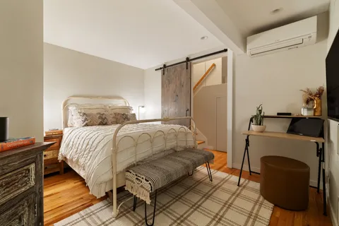a bedroom with a bed and wooden floor