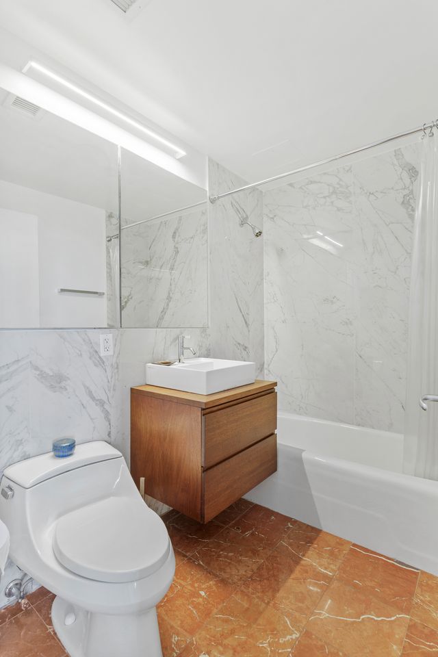 230 Ashland Place, Unit 26A Brooklyn, NY 11217 - Photo 8 of 12 a bathroom with a sink a toilet and bathtub