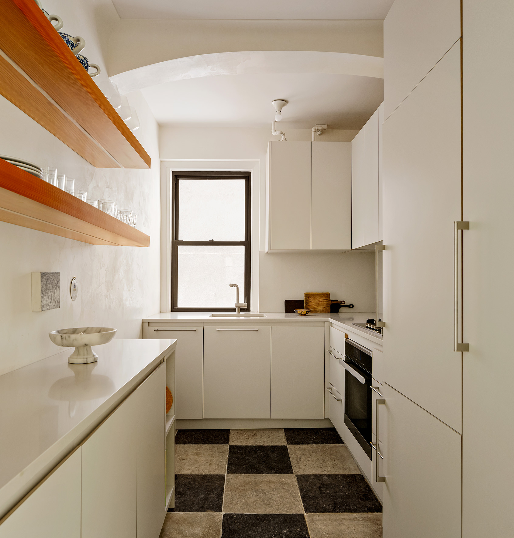 21 East 10th Street, Unit 7D Manhattan, NY 10003 - Photo 5 of 11 a kitchen with a sink a stove a refrigerator and white cabinets