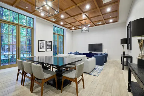 a view of a dining room with furniture a chandelier and wooden floor