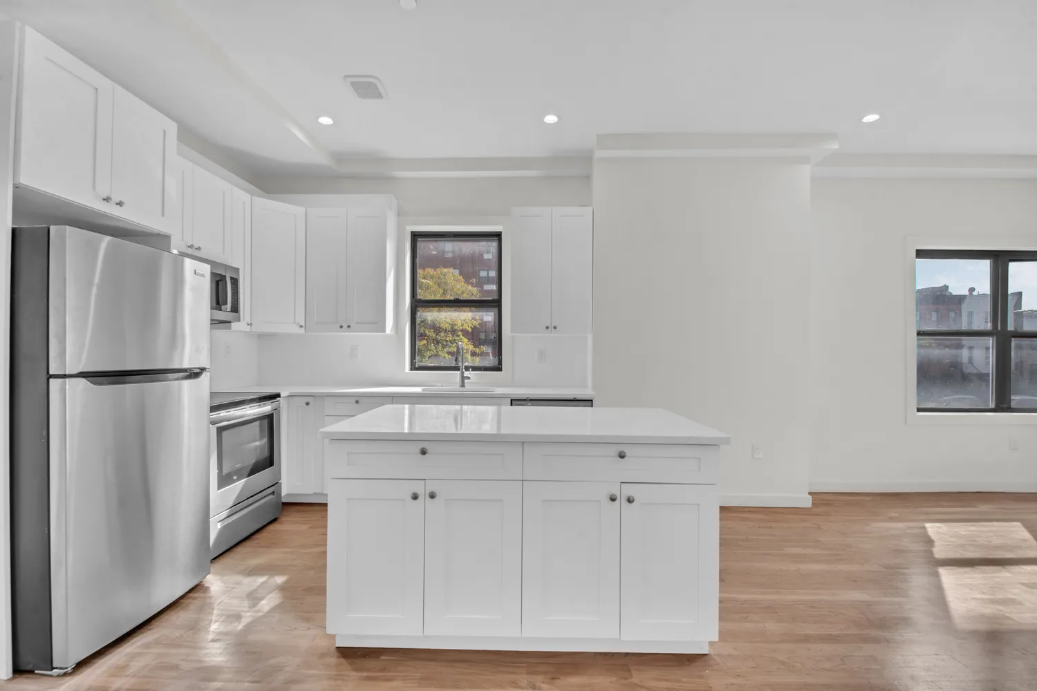 a kitchen with white cabinets and stainless steel appliances