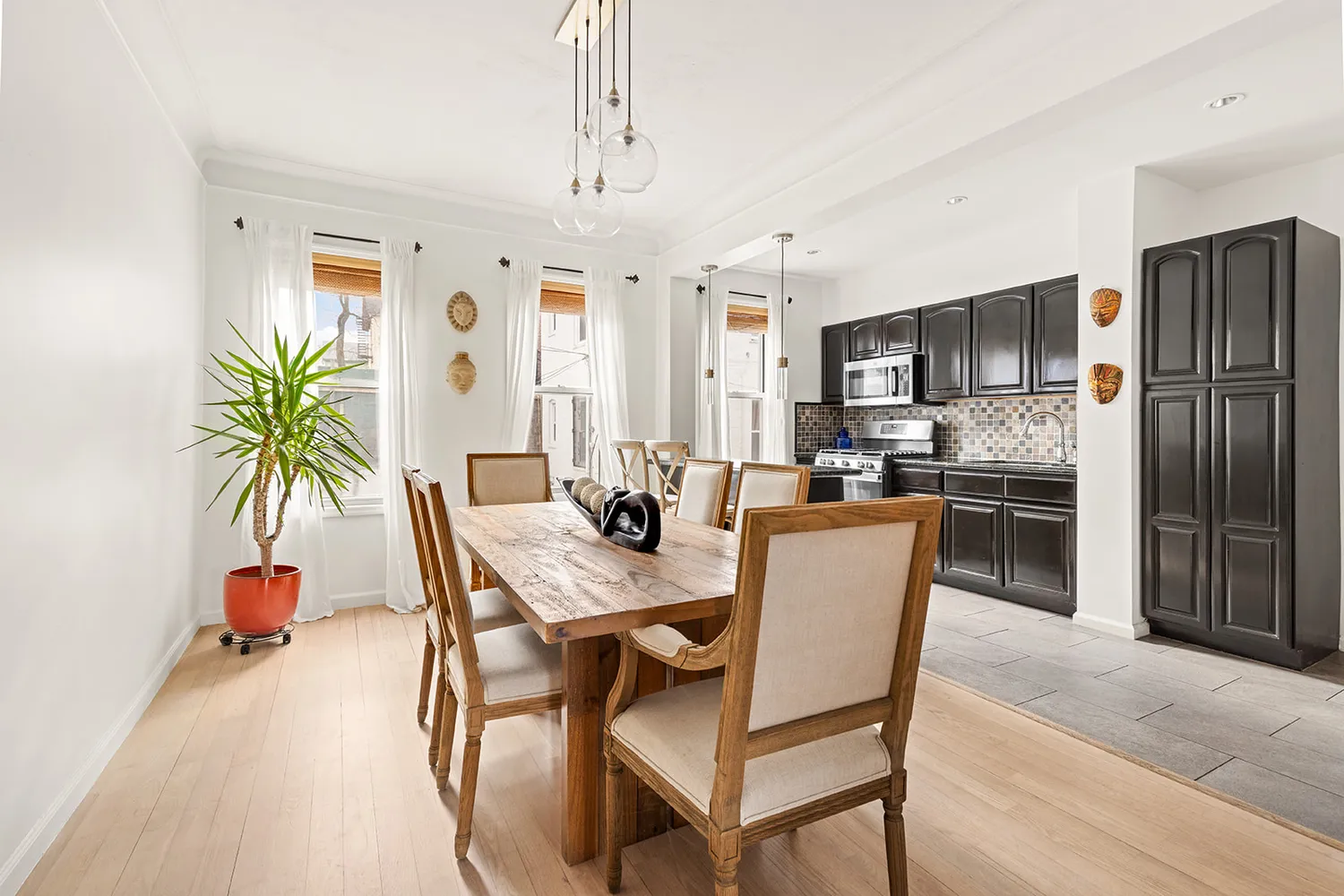 a dining room with furniture a chandelier and kitchen view