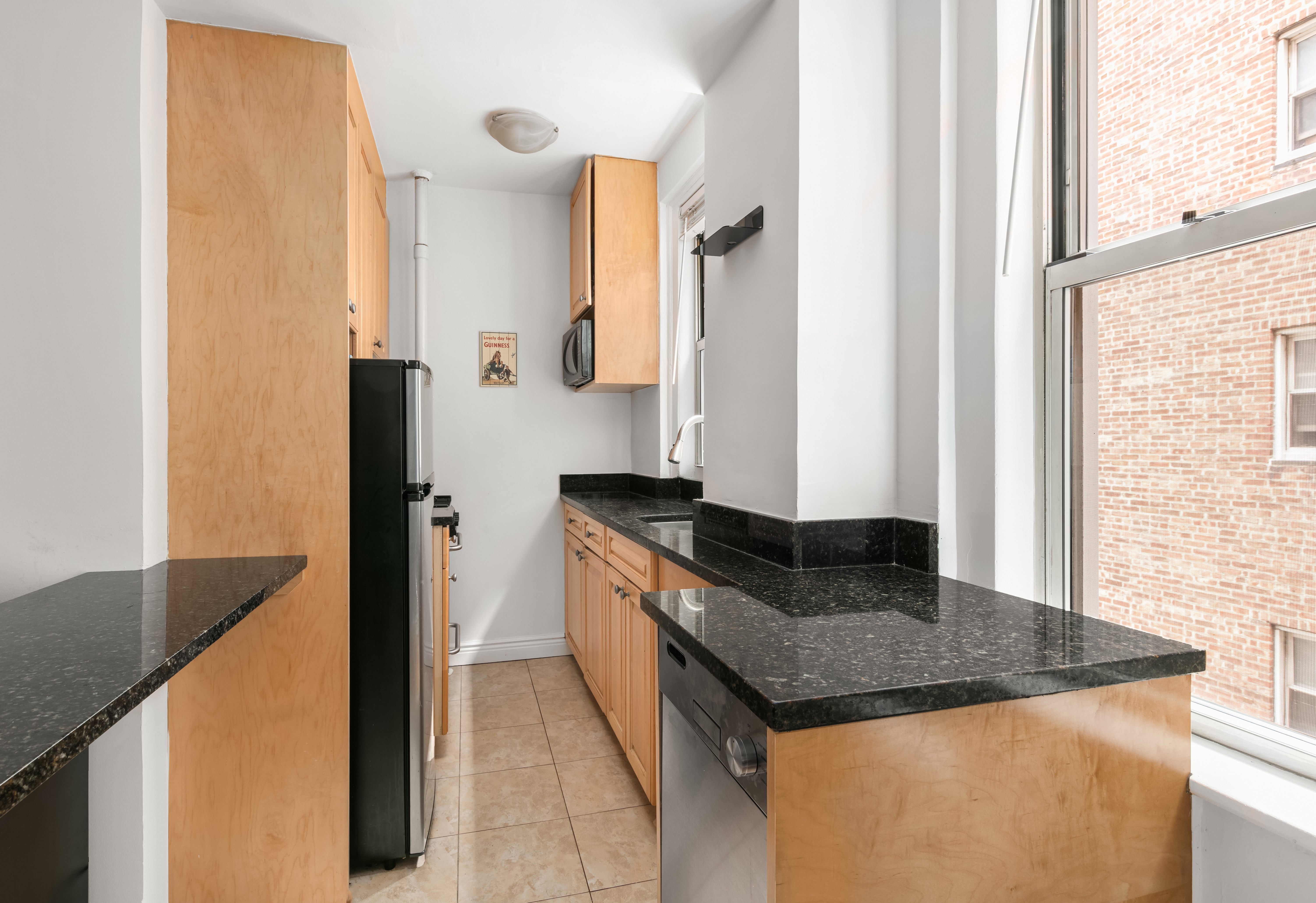 333 East 43rd Street, Unit 709 Manhattan, NY 10017 - Photo 3 of 15 a kitchen with granite countertop a sink and a refrigerator