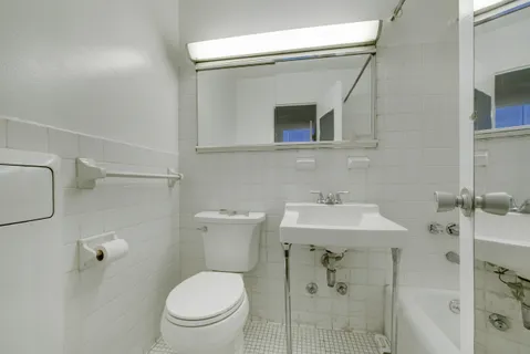 a bathroom with a toilet sink and mirror