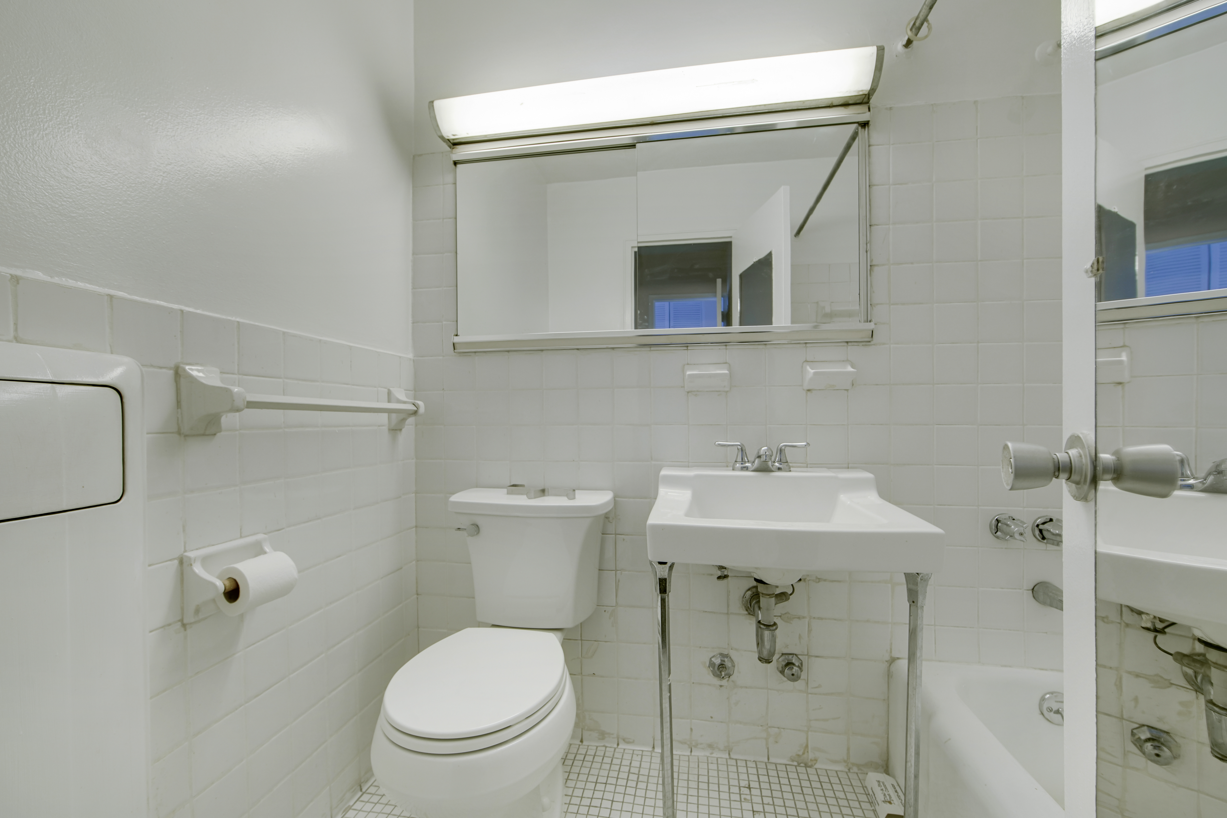 220 East 60th Street, Unit 3F Manhattan, NY 10022 - Photo 6 of 8 a bathroom with a toilet sink and mirror