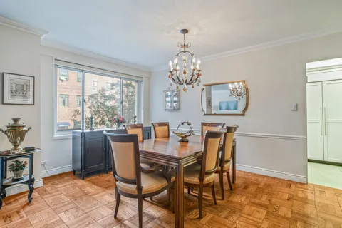 a dining room with furniture a rug and a chandelier