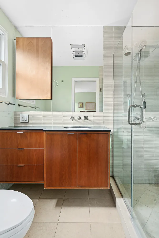a bathroom with a granite countertop sink a mirror and a shower