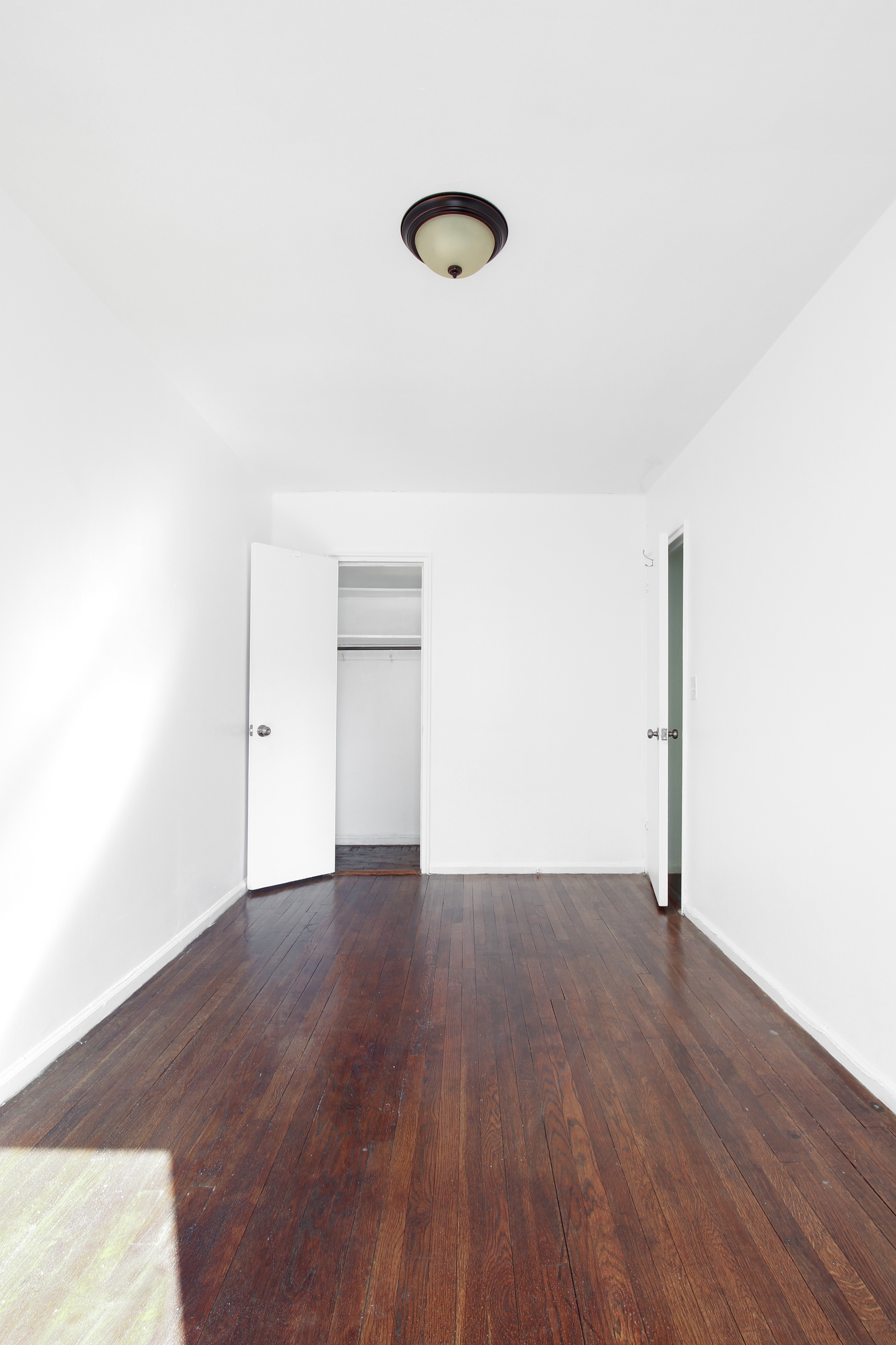 315 East 56th Street, Unit 5H Manhattan, NY 10022 - Photo 8 of 9 a view of an empty room with wooden floor