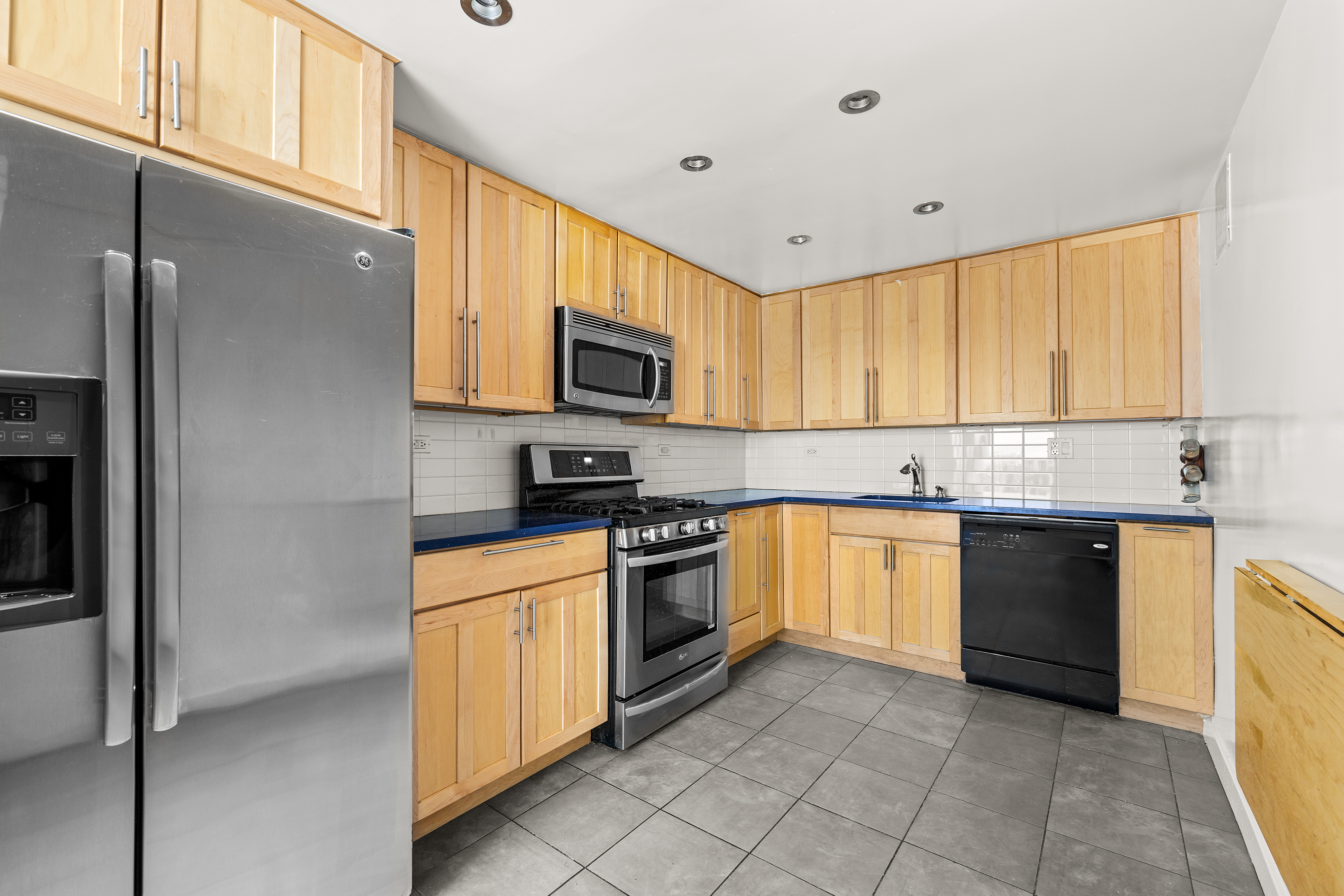 16 West 16th Street, Unit 14NN Manhattan, NY 10011 - Photo 3 of 10 a kitchen with stainless steel appliances granite countertop a refrigerator and a stove top oven