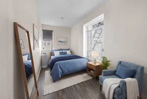 a bedroom with a bed couch and a window