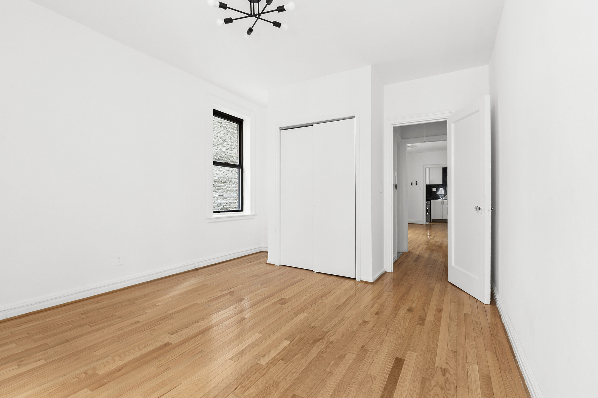 205 West 10th Street, Unit 3D Manhattan, NY 10014 - Photo 5 of 7 an empty room with wooden floor and a ceiling fan